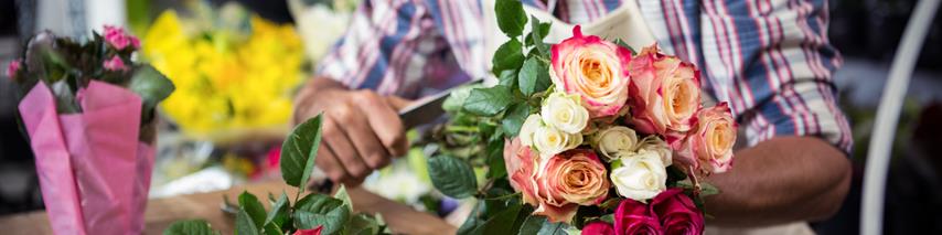 Business man sorting flower arrangements in florist