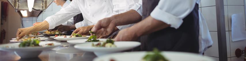 Several staff prepping food in busy restaurant 