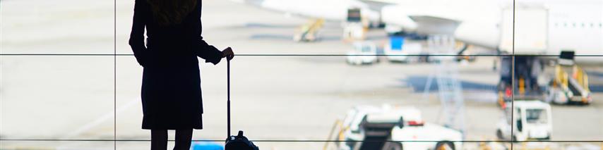 Business woman waiting for flight with suitcase